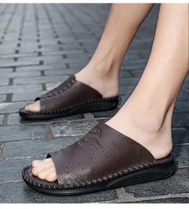 Détail montrant des claquettes en cuir marron foncé avec motif gaufré et semelle souple