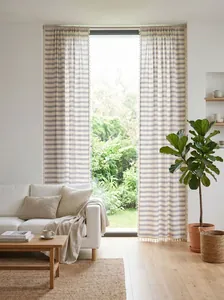 Light French navy blue striped curtains with decorative edge tassels in a bright living room