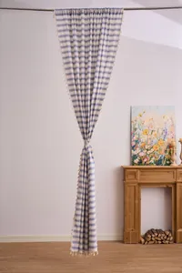 French style navy blue striped sheer curtain with decorative tassels in a home setting.