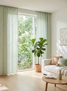 French farmhouse sage green gingham check curtains with handmade tassels in a bright room.