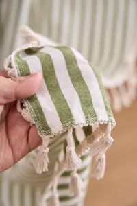 Vista detallada de tela a rayas verdes de estilo francés con borlas blancas decorativas