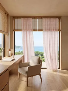 Close-up detail of light French pink striped sheer curtains with elegant tassel trim