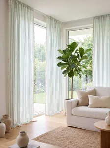 Detailed view of light green striped cotton linen sheer curtains with cream tassel trim