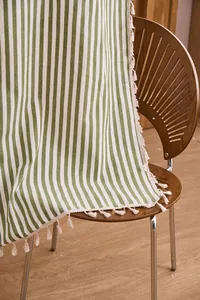 Detalle de cortina a rayas verdes y blancas con delicados acabados de borlas beige