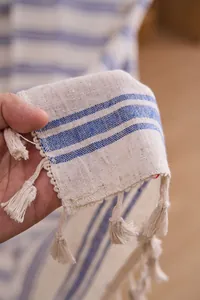 Detail of French-style cream curtain with navy stripes and tassels