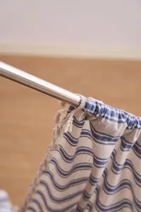 Close-up of French style navy striped curtain fabric showing rod pocket and tassel details