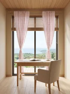 Elegant light French pink striped curtains with decorative tassels in a coastal home office.