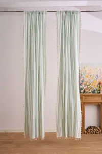 Mint green and white striped sheer curtains with cream tassel edges in a room setting
