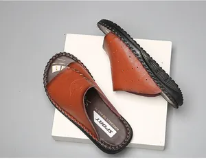 Vue détaillée des claquettes en cuir marron montrant la texture et la semelle