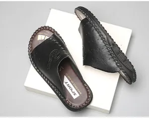 Vue détaillée de claquettes noires tendance avec logo sport blanc et bordures cousues main