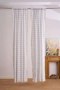 Detailed view of modern blue and white striped curtains with decorative tassels
