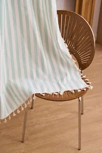 Detailed view of striped mint and white cotton linen curtain with elegant white tassels