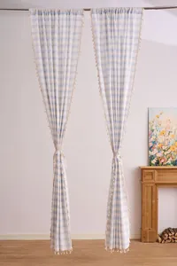 Detail of striped semi-blackout curtains with decorative tassels for living rooms.