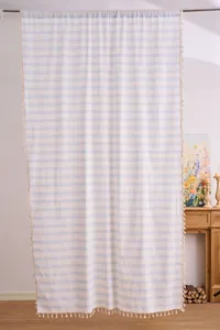 Detail view of light blue striped curtain with delicate fringe tassels along the edge