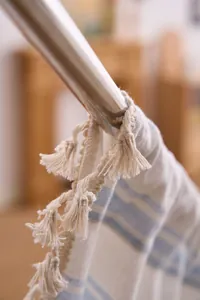 Close-up detail of striped curtain fabric featuring decorative tassels and soft texture.