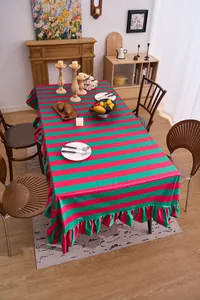 Lifestyle view of red and green striped tablecloth featuring elegant ruffled flounce edges