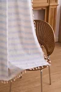 Detail view of modern light blue striped curtain fabric with tassel fringe edges