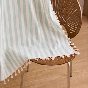 Pastel cream and mint green striped cotton linen curtain with decorative tassel fringe.