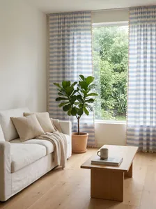 Detailed view of blue striped cotton linen curtains with tassels in a living room
