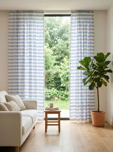 Blue and white striped linen curtains with tassel trim in a bright living room.