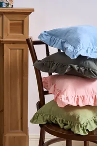 Stacked French style ruffled throw pillow covers in assorted elegant pastel colors