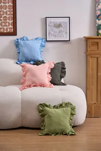 Elegant French ruffled solid color decorative pillowcases arranged on a modern white bouclé sofa