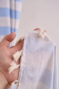 Close-up detail of cotton linen striped curtain with decorative white tassels