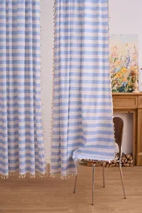 Detail of American style blue and white striped cotton linen tassels curtains in room