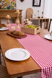 Detail of a red and white checkered cotton linen table runner with ruffled edges