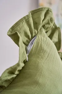 Detailed view of the quality hidden zipper on a green French ruffled cushion cover