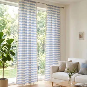 Blue and white striped cotton-linen curtains with tassel trim in a bright living room.