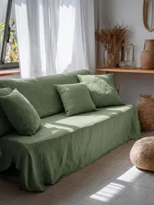 Copridivano in cotone lavato verde salvia con set di cuscini in un soggiorno luminoso