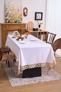 Λεπτομέρεια λευκού βελούδινου τραπεζομάντιλου με κομψή χρυσή κεντημένη δαντέλα.