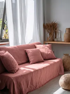 Copridivano in cotone lavato rosa antico con federe coordinate in un soggiorno accogliente