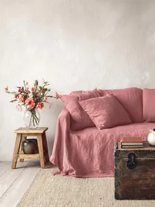 Vista dettagliata di un copridivano in cotone lavato rosa antico con trama di lino rustico