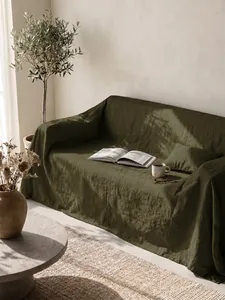 Dettaglio di un copridivano in cotone lavato verde oliva in un elegante ambiente naturale