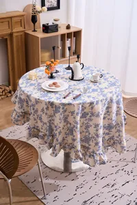 Detail of French vintage blue floral round tablecloth with elegant ruffled edges