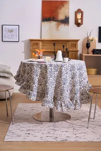 Full view of vintage floral circular tablecloth with elegant ruffle edge in dining setting