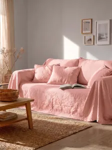 Vista dettagliata del copridivano in cotone lavato rosa tenue per l'arredo del soggiorno