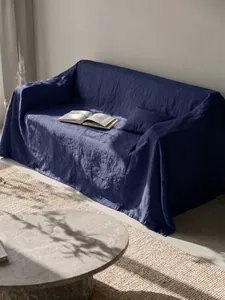 Dettaglio di un copridivano in cotone lavato blu navy drappeggiato su un divano.