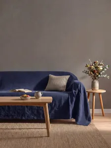 Dettaglio del copridivano in cotone lavato blu scuro in un accogliente soggiorno