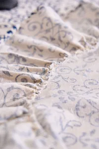 Macro detail of French vintage floral print tablecloth with elegant ruffled edge and texture