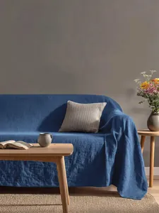 Copridivano in cotone lavato blu per un soggiorno moderno e accogliente.