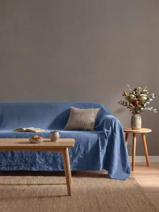 Copridivano in cotone lavato blu drappeggiato in un soggiorno dal design moderno