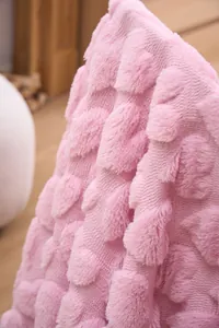 Detailed macro view of plush pink blanket showing intricate carved leaf pattern texture