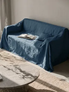 Elegante copridivano in cotone lavato blu scuro esposto in un soggiorno soleggiato