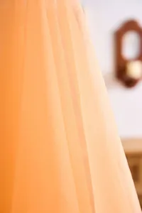Detailed macro view of soft orange tulle fabric for elegant wedding arch decoration