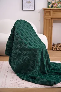 Luxurious dark green plush blanket with a textured carved pattern in a cozy room setting