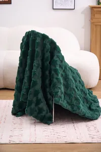 Close-up of dark green plush blanket with textured Christmas tree pattern