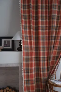 Eleganti tende francesi a quadri arancioni con frange a nappe bianche e trama del tessuto